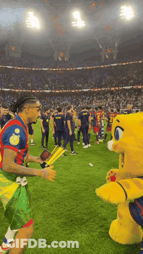 Soccer Players Standing With Mascot GIF