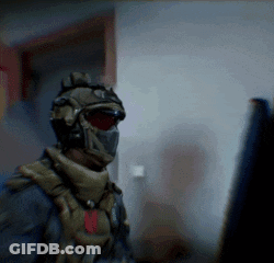 Soldier In Helmet And Mask Looking At Computer Monitor GIF