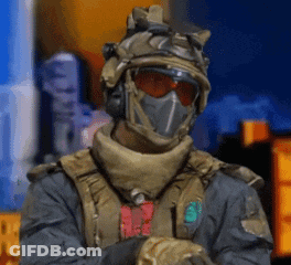 Soldier In Helmet And Mask Standing In Front Of Building GIF
