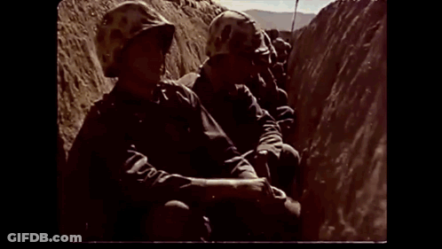 Soldier In Helmet Walking Down Dirt Hill GIF