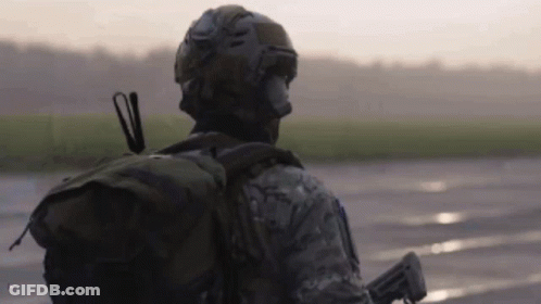 Soldier Walking On Wet Road With Backpack Gun GIF