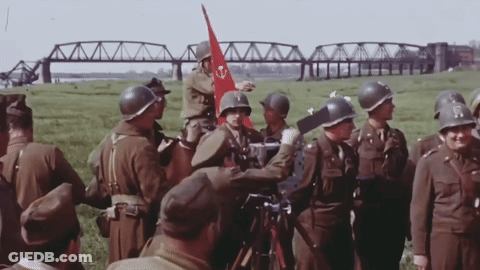 Soldiers Gathered In Field With Red Flag GIF