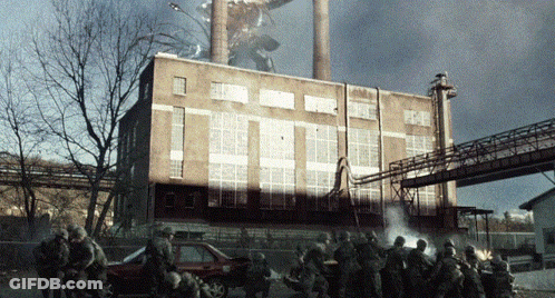 Soldiers Gathered In Front Of Burning Building GIF
