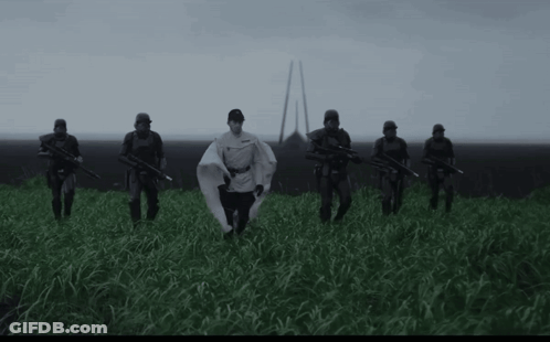 Soldiers In Field With Man In White Cape GIF