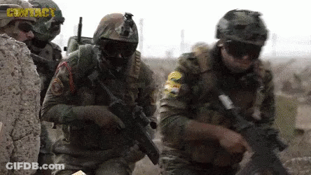 Soldiers In Helmets And Goggles Holding Guns In Field GIF