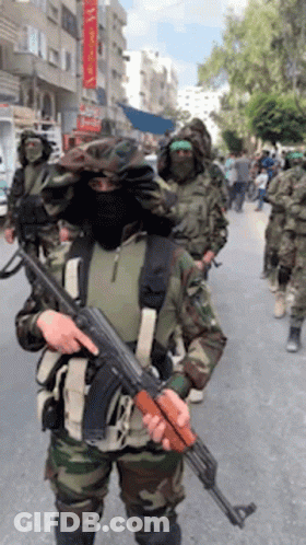 Soldiers Marching Down Street One Holding Gun GIF