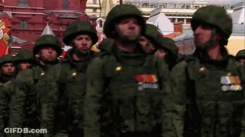 Soldiers Marching In Front Of Building With Victory Banner GIF