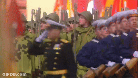 Soldiers Marching In Line With Man In Black Uniform GIF
