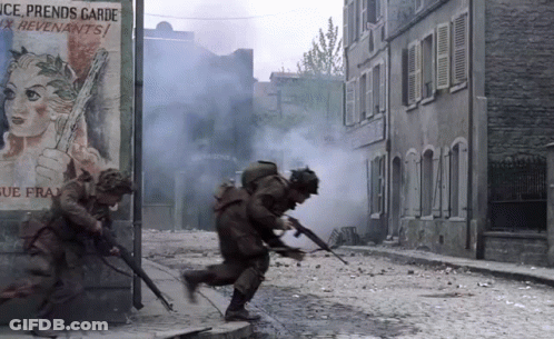 Soldiers Running Down A Street In Front Of A Sign That Says Ice Prends Garde GIF