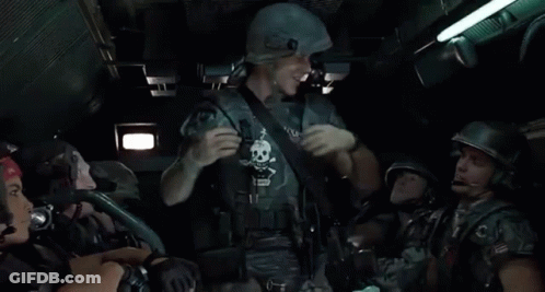 Soldiers Standing Around Man In Helmet And Apron GIF