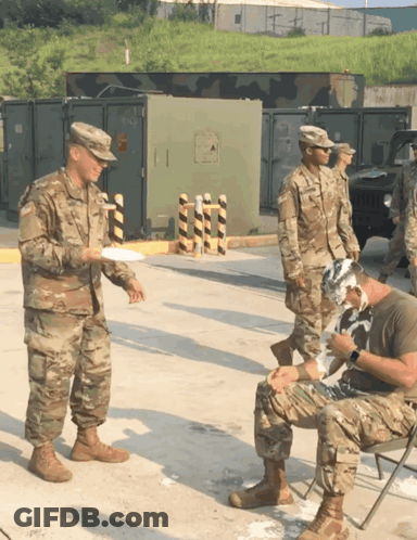 Soldiers Standing Around Man With Bandaged Head GIF