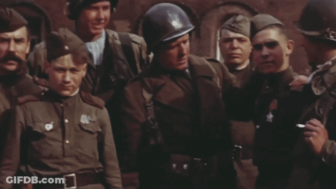 Soldiers Standing Around Man With Star On Chest GIF
