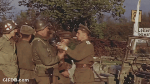 Soldiers Standing In Front Of Leiter Olzwar Sign GIF