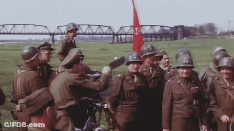 Soldiers Standing With Red Flag With Letter T GIF