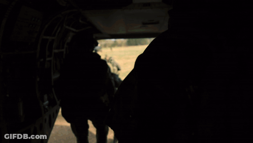 Soldiers Walking Across Field With Helicopter GIF