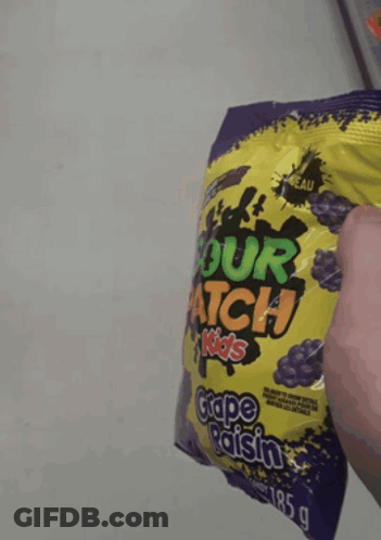 Someone Is Holding A Bag Of Sour Patch Kids Grape Raisin GIF