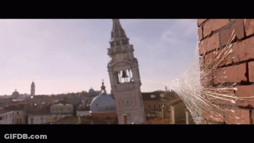 Spider Web Hanging From Brick Wall In Front Of Clock Tower GIF