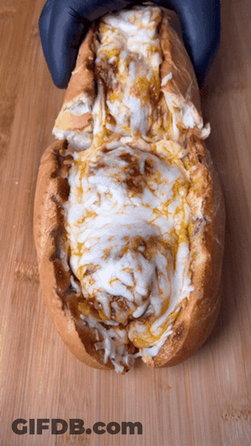 Splitting A Cheesy Meatball Sub Into Two GIF