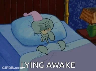 Squidward From Spongebob Squarepants Is Laying In A Bed With A Nightcap On His Head . GIF