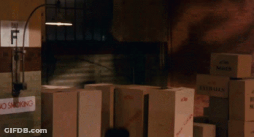 Stack Of Boxes In Dark Room With No Smoking Sign GIF