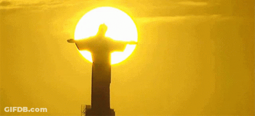 Statue Of Jesus In Front Of Yellow Sun GIF