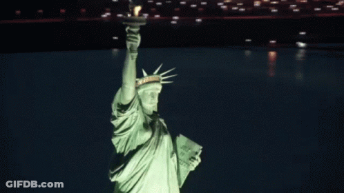 Statue Of Liberty Lit Up At Night Holding Book Saying Just Do It GIF