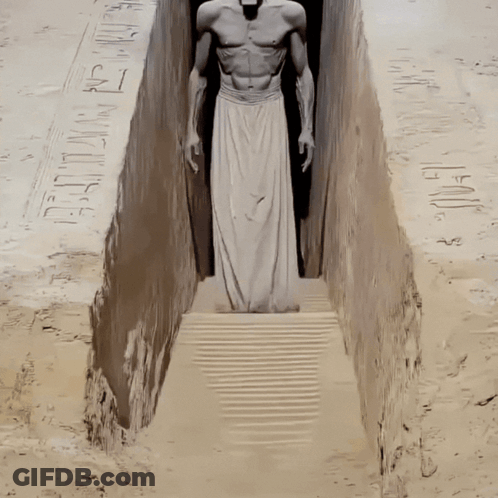 Statue Of Man In White Skirt In Narrow Passageway GIF