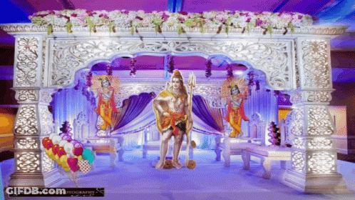 Statue Of Man With Trident In Front Of Purple Decoration GIF