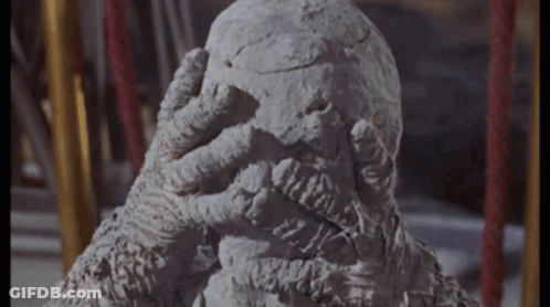 Statue Of Monster Covering Face With Hand GIF