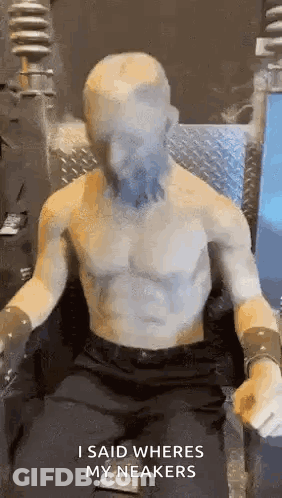 Statue Of Shirtless Man Sitting With Face Covered GIF
