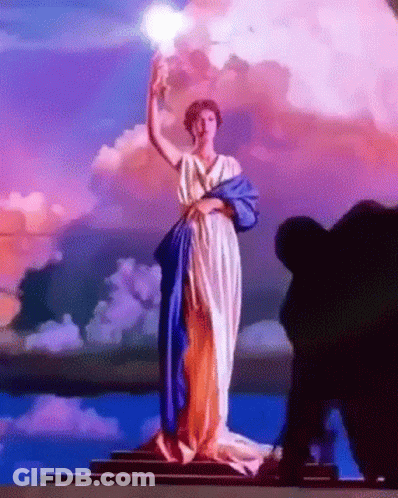 Statue Of Woman In Blue And White Dress Holding Light GIF