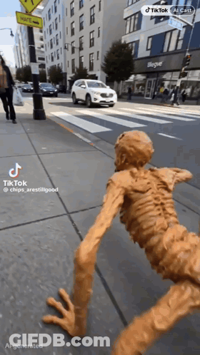Statue Skeleton Crawling Down Sidewalk In Front Of Bleagle Building GIF