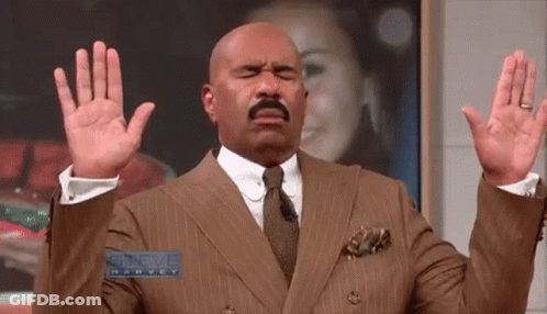 Steve Harvey In Suit And Tie With Hands Up GIF