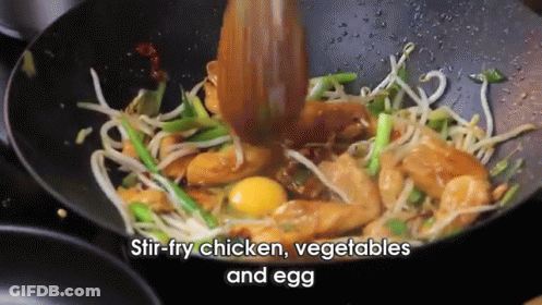 Stir Fry Chicken Vegetables And Egg In A Wok With A Wooden Spoon GIF