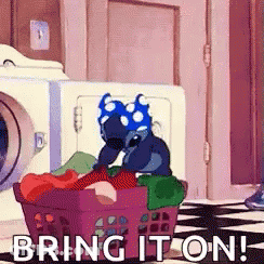 Stitch From Disney 'S Lilo And Stitch Is Sitting In A Laundry Basket Full Of Clothes . GIF