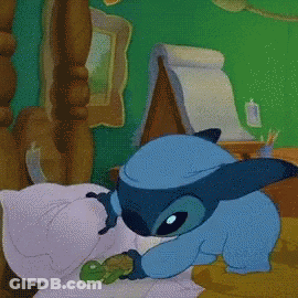 Stitch Laying On Bed Holding Green Frog GIF