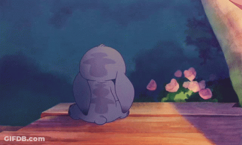 Stitch Sitting On Wooden Table Eyes Closed GIF