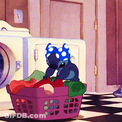 Stitch Wearing A Blue And White Polka Dot Headband Sits In A Laundry Basket GIF