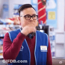Store Worker In Glasses And Blue Vest Covering Mouth GIF