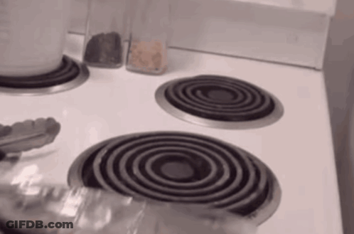 Stove Top With Three Burners And Tongs GIF