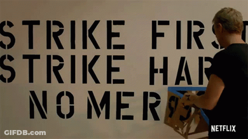 Strike First Strike Hard No Mercy Stenciled On Wall GIF