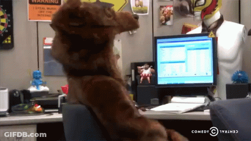 Stuffed Animal At Desk With Computer And Warning Sign GIF