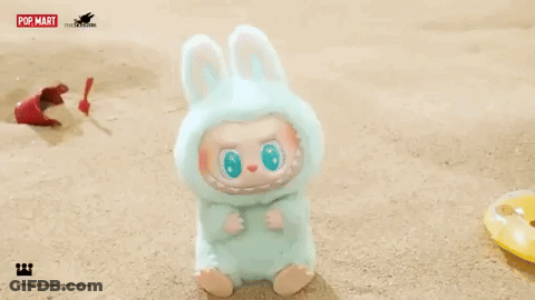 Stuffed Animal In Bunny Costume Sitting On Beach GIF