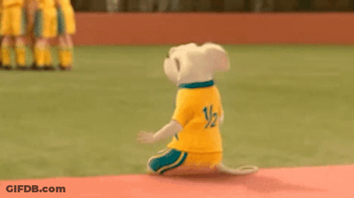 Stuffed Animal Kneeling In Field Wearing Yellow Shirt GIF