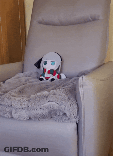 Stuffed Animal Sitting In Chair With Blanket GIF