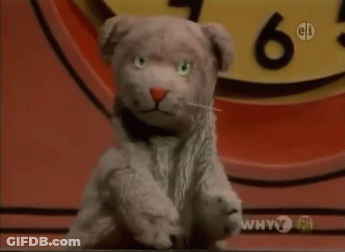 Stuffed Animal Sitting In Front Of Clock Saying Why 7 GIF