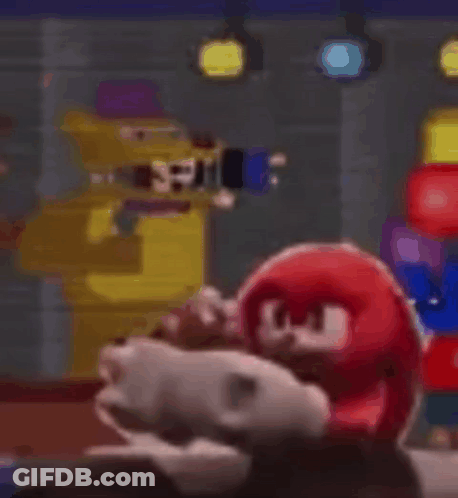 Stuffed Animal Sitting In Front Of Yellow Robot GIF