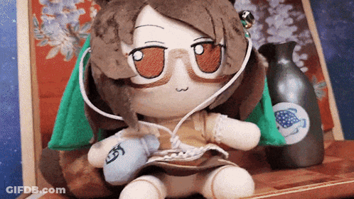 Stuffed Animal With Glasses And Headphones Next To Vase GIF