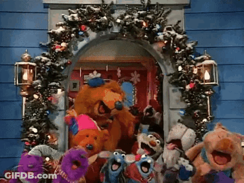 Stuffed Animals In Front Of Christmas Wreath GIF