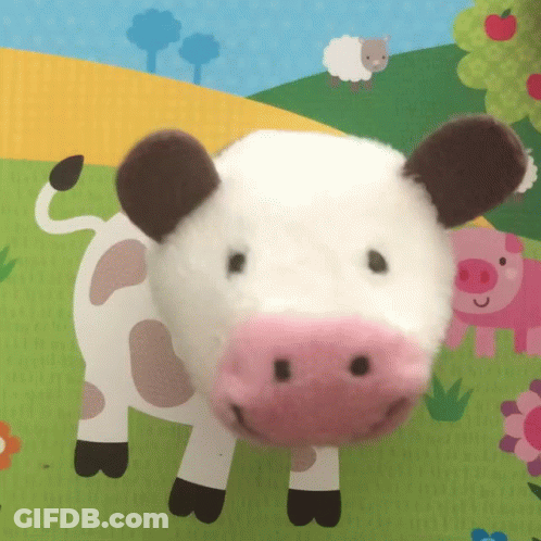 Stuffed Cow With Pink Nose Lying On Mat GIF